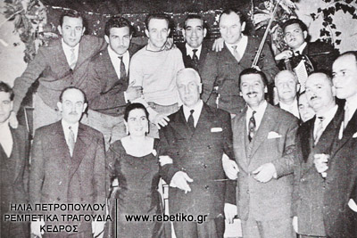Ο Παυσανίας Κατσώτας επισκέπτεται τα μπουζούκια, όπου ποζάρει ανάμεσα στην Χρυσάφη και τον Μητσάκη, και διαφόρων άλλων. (γύρω στα 1960)