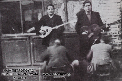 Δύ λούστροι γυαλίζουν τα παπούτσια του Χρήστου Μίγκου (μπουζούκι) και του Μίμη Χαμαμτζή (κιθάρα), στον συνοικισμό Ροτόντα (Θεσσαλονίκη, 1943)