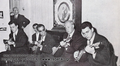 Φωτογραφία από την συναυλία του Μάρκου Βαμβακάρη, από την έκθεση Ρεμπέτικα τραγούδια- τεκμήρια, στο Χίλτον. Μαζί του είναι οι γιοί του Στέλιος και Δομένικος και ο Κερομύτης (8-5-1968)