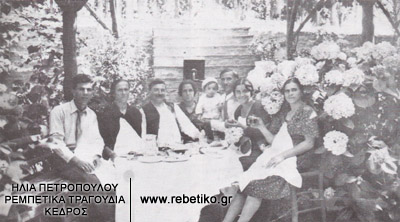 Ο Στέφανος Μιλάνος (τρίτος από αριστερά), στα βαφτήσια του γιού του Καρόλου. Το γλεντι έγινε στο σπίτι του νονού Γιάννα Παπαγγελή, στον Βόλο (Ιούλιος 1933)