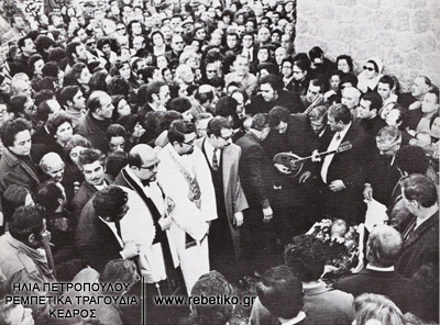 Η κηδεία του Μάρκου Βαμβακάρη έγινε στις 9-2-1972, στο καθολικό τμήμα του Γ΄ Νεκροταφείου. Στην φωτογραφία φαίνεται το ανοιχτό φέρετρο. Ο Δομένικος και ο Στέλιος παίζουν μπουζούκι, κλαίγοντας, πάνω από τον πατέρα τους.Λίγο πιο δίπλα ο Γενίτσαρης