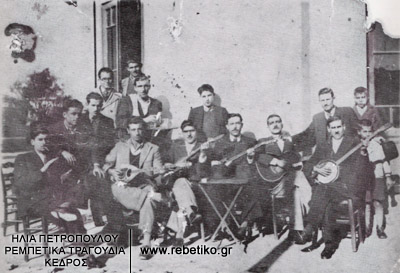 Μία παρέα γλεντζέδων, στο ουζερί των τότε συνεταίρων Γενίτσαρη και Παπαϊωάννου, στα Καμίνια του Πειραιά. Διακρίνονται: ο Γενίτσαρης (αριστερά), και ο Παπαϊωάννου (όρθιος, μπροστά στο παράθυρο), με δίσκο στα χέρια και πετσέτα στον ώμο