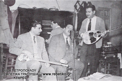 Ο Γενίτσαρης (κρατάει μισομπούζουκο), ο Ζαμπέτας, ο Νίκος Μπουρλιάσκος, ακούνε κάποιον πελάτη που τραγουδάει με μεράκι, το 1949
