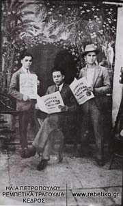 Ο Ροβερτάκης, με δύο φίλους του, το 1928, που πρωτοδημοσίευσε σε δίφυλλο το τραγούδι του "Γλυκιά Τσιγκάνα". Η φωτογραφία είναι τραβηγμένη από υπαίθριο φωτογράφο, μπροστά από το ρολόι του Πειραιά.